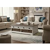 Landelijke salontafel wit hout met bruin blad, vier lades en rieten manden in een moderne woonkamer setting.