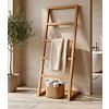 Teakhouten handdoekrek ladder met beige wafelhanddoek in een minimalistische Japandi badkamer met olijfboom.