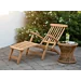Klassieke teakhouten deckchair met zilverkleurig RVS beslag op een stenen terras, inclusief voetensteun en naast een rotan bijzettafel